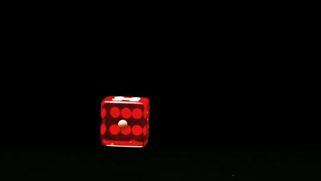 Red-dice-falling-and-bouncing-close-up-on-black-background