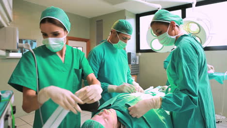 Surgeon-and-a-team-operating-a-patient-while-checking-a-monitor