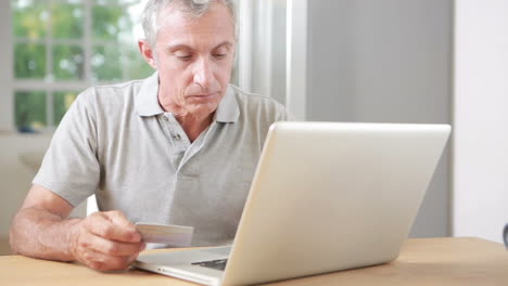 Man-using-his-laptop-and-credit-card