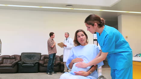 Krankenschwester-Schiebt-Eine-Schwangere-Frau-Im-Rollstuhl