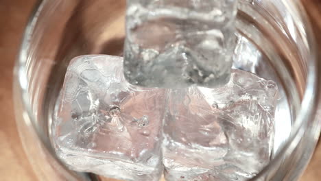 Eiswürfel-Mit-Zange-Ins-Glas-Geben-Und-Whiskey-Darüber-Gießen