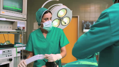 Nurse-holding-a-mask-while-looking-at-surgeon