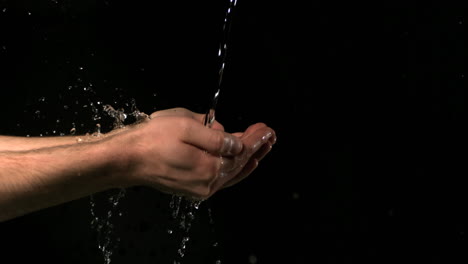 Fließendes-Wasser-Fällt-Auf-Die-Hände-Des-Mannes