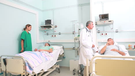 Smiling-nurse-and-doctor-talking-with-patient