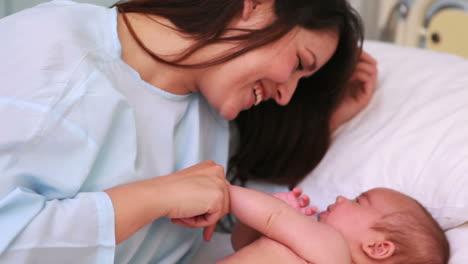 Madre-Feliz-Con-Su-Bebé-En-Una-Cama