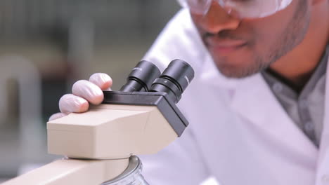 Estudiante-Mirando-A-Través-Del-Microscopio-Mientras-Uno-Mira