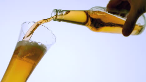 Hand-pouring-bottle-of-beer-into-glass