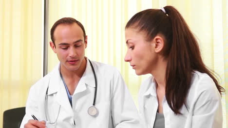 Doctor-talking-to-a-woman-while-they-sit-in-a-waiting-room