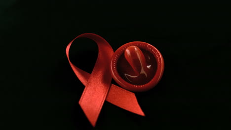 Condom-dropping-down-beside-red-ribbon