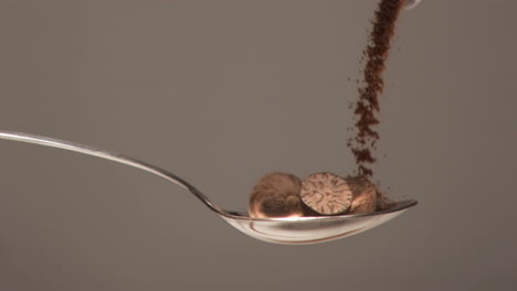 Silver-spoon-filled-in-super-slow-motion-with-nuts-and-powder-falling-on-it