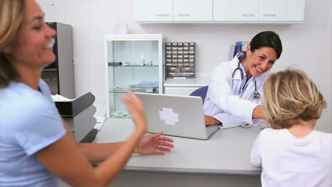 Smiling-doctor-in-her-office-with-patient-