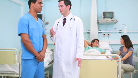 Male-nurse-talking-to-a-doctor