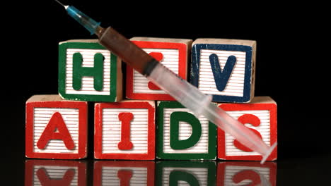 Syringe-falling-on-wooden-blocks-spelling-Aids-and-Hiv