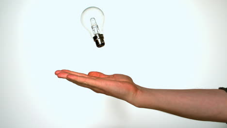 Mans-hand-throwing-light-bulb