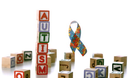 Autism-ribbon-falling-beside-blocks-spelling-autism