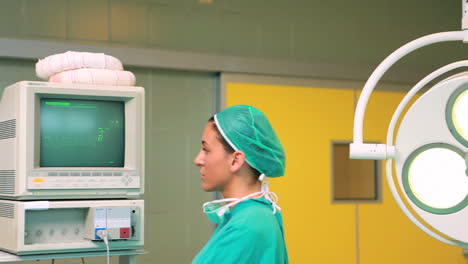 Smiling-female-surgeon-standing-next-to-a-monitor