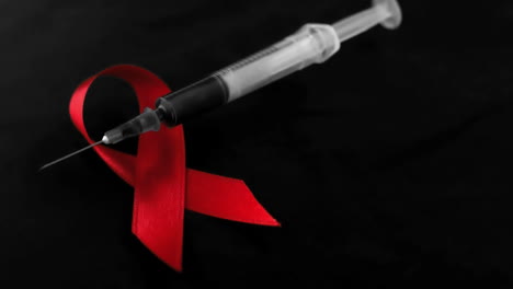Syringe-dropping-down-beside-red-ribbon-