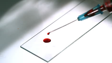 Blood-dropping-from-syringe-onto-slide
