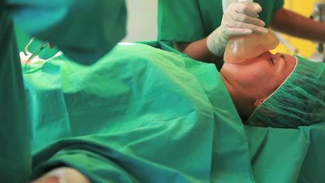 Young-anesthetist-holding-mask-over-patients-mouth