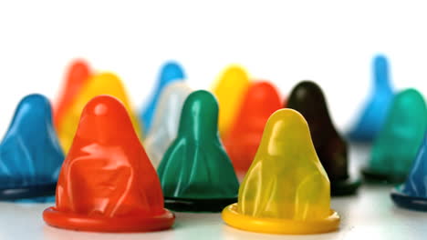 Yellow-condom-falling-on-surface-with-many-condoms