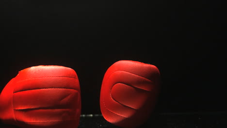 Guantes-De-Boxeo-Rojos-Cayendo-Sobre-Fondo-Negro