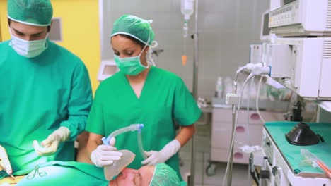 Krankenschwester-Trocknet-Stirn-Eines-Konzentrierten-Chirurgen