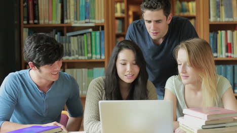 Vier-Studenten-Mit-Einem-Laptop-In-Einer-Bibliothek