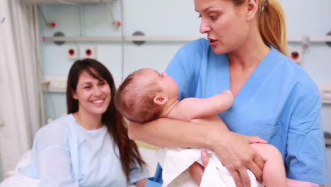 Enfermera-Sosteniendo-A-Un-Bebé-Recién-Nacido