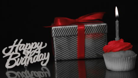 Kerze-Auf-Cupcake-Geblasen-Neben-Geschenk-Und-Happy-Birthday-Zeichen