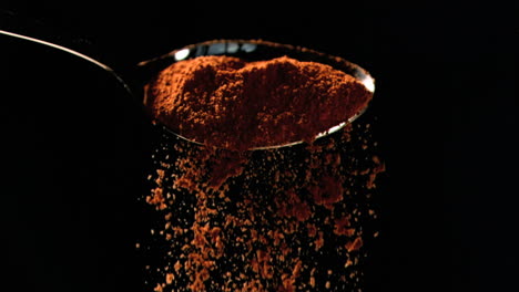 Orange-powder-falling-in-super-slow-motion-out-of-a-spoon