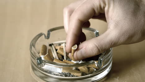 Man-putting-out-cigarette-in-ashtray