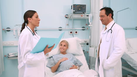 Doctor-holding-files-while-talking-to-a-pregnant-woman