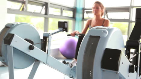 Two-women-drawing-on-row-machine