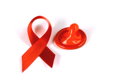 Condom-falling-over-beside-red-ribbon-