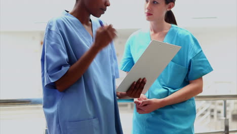 Female-nurse-and-intern-holding-a-clipboard