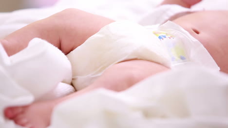 Neugeborenes-Baby-In-Windeln-Liegt-Auf-Einem-Bett-Mit-Decken