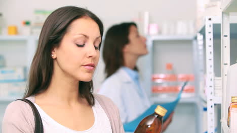 Cliente-En-Una-Farmacia-Sosteniendo-Una-Botella-De-Medicamento.