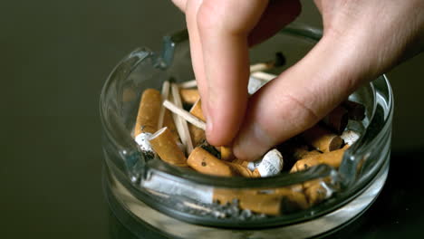 Hand-putting-cigarette-out-in-ashtray