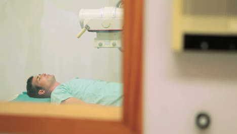 Paciente-Acostado-En-Una-Mesa-De-Examen-Mientras-Se-Realiza-Una-Radiografía.