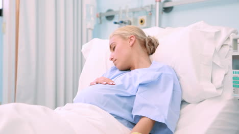 Paciente-Embarazada-Dormida-Acostada-En-Una-Cama-Mientras-Sostiene-Su-Vientre