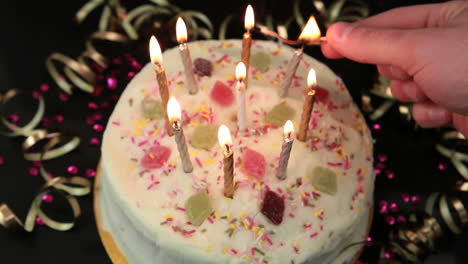 Hand-Zündet-Kerzen-Auf-Geburtstagstorte-An
