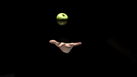 Hand-Wirft-Einen-Grünen-Apfel-Auf-Schwarzem-Hintergrund