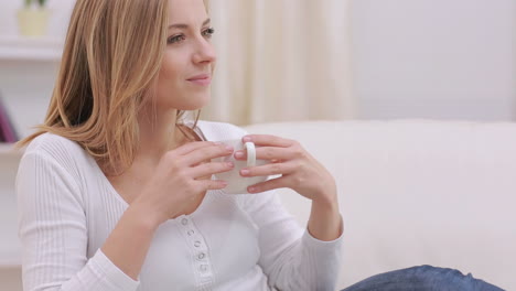Calm-woman-thinking-while-drinking-a-hot-drink