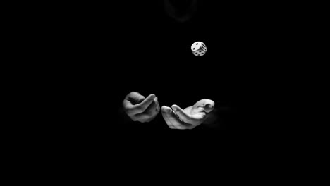 Hands-juggling-three-dice-in-black-and-white