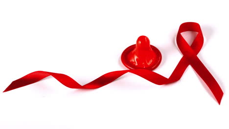 Condom-dropping-down-beside-Aids-red-ribbon-symbol-