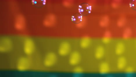 Bubbles-floating-against-rainbow-flag