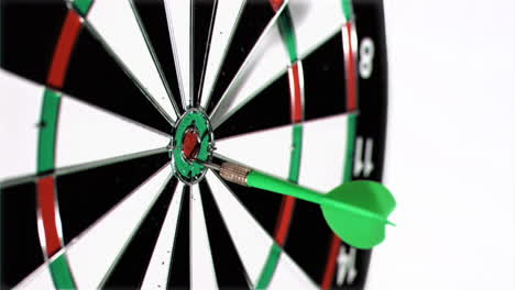 Green-plastic-dart-in-a-super-slow-motion-thrown-at-the-middle-of-a-dart-board