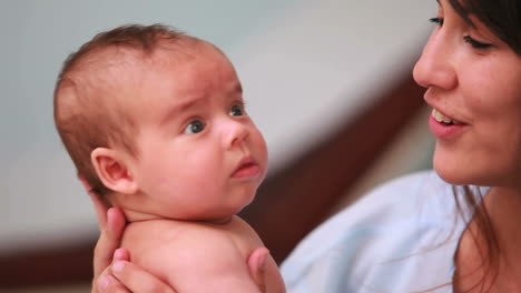 Madre-Feliz-Sosteniendo-A-Un-Bebé-En-Pañales