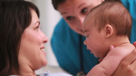 Happy-mother-holding-a-baby-boy-in-diaper-with-a-doctor