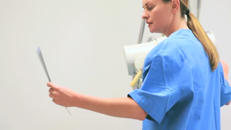 Nurse-looking-at-xray-while-proceeding-a-radiography-on-a-patient